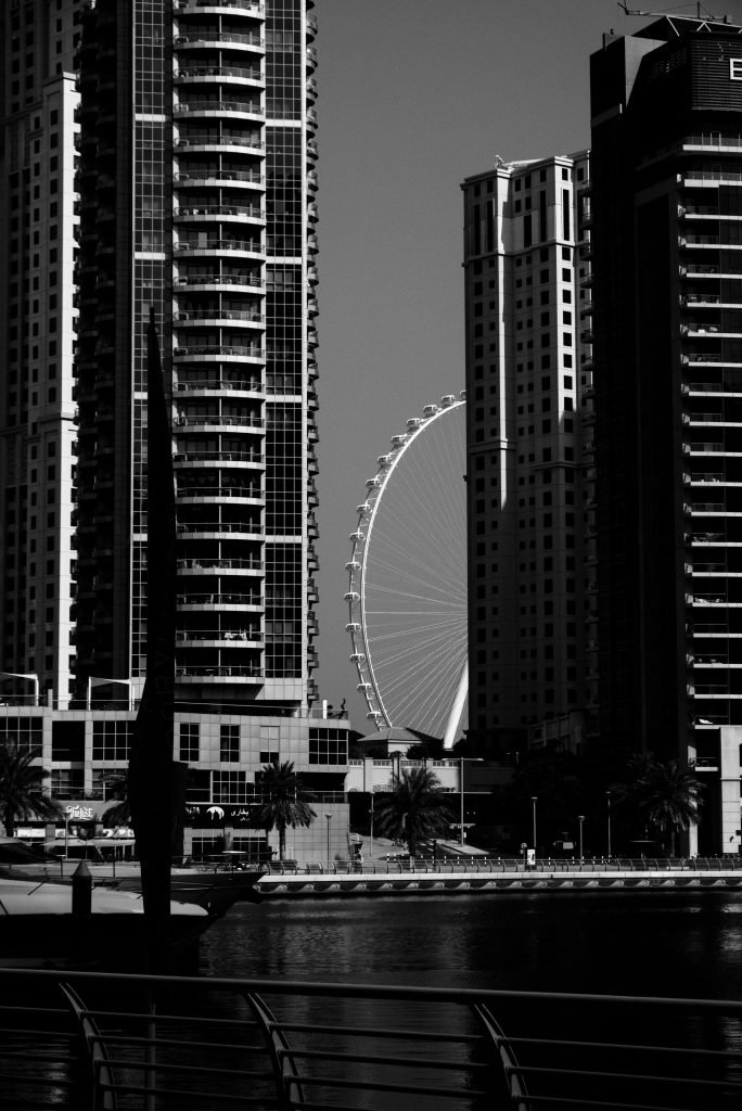 Dramatic black and white view of Dubai Marina featuring the iconic Ain Dubai Ferris Wheel.